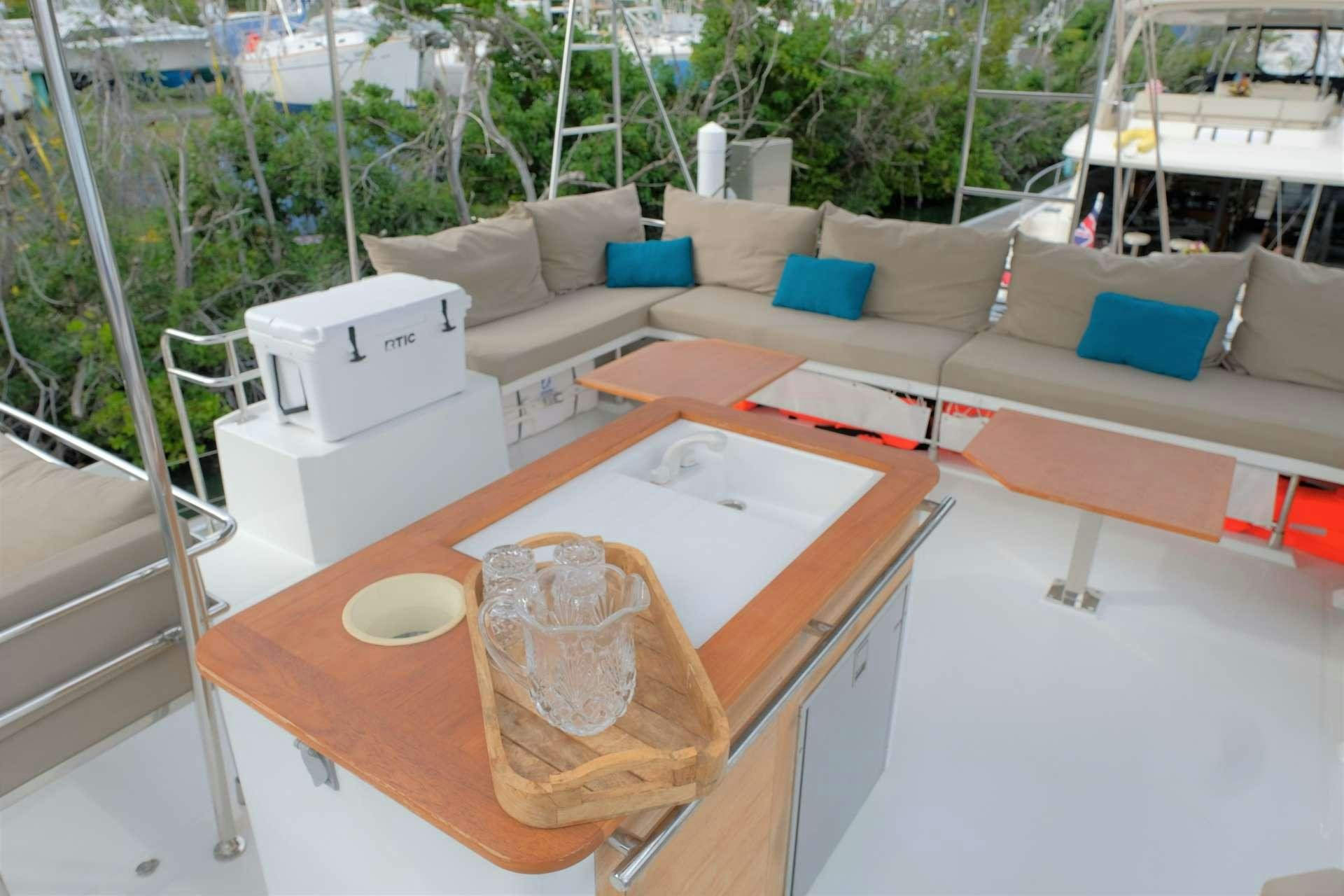 a table with a glass and a couch on it aboard PORT TO VINO Yacht for Charter