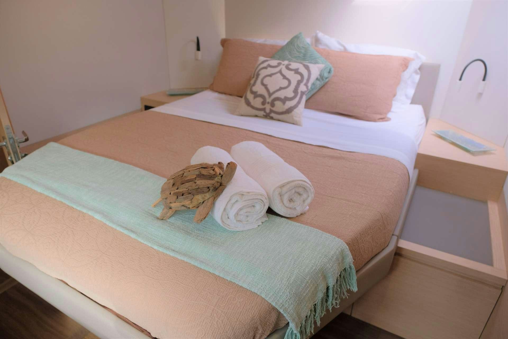 a bed with a pillow and a towel on it aboard PORT TO VINO Yacht for Charter