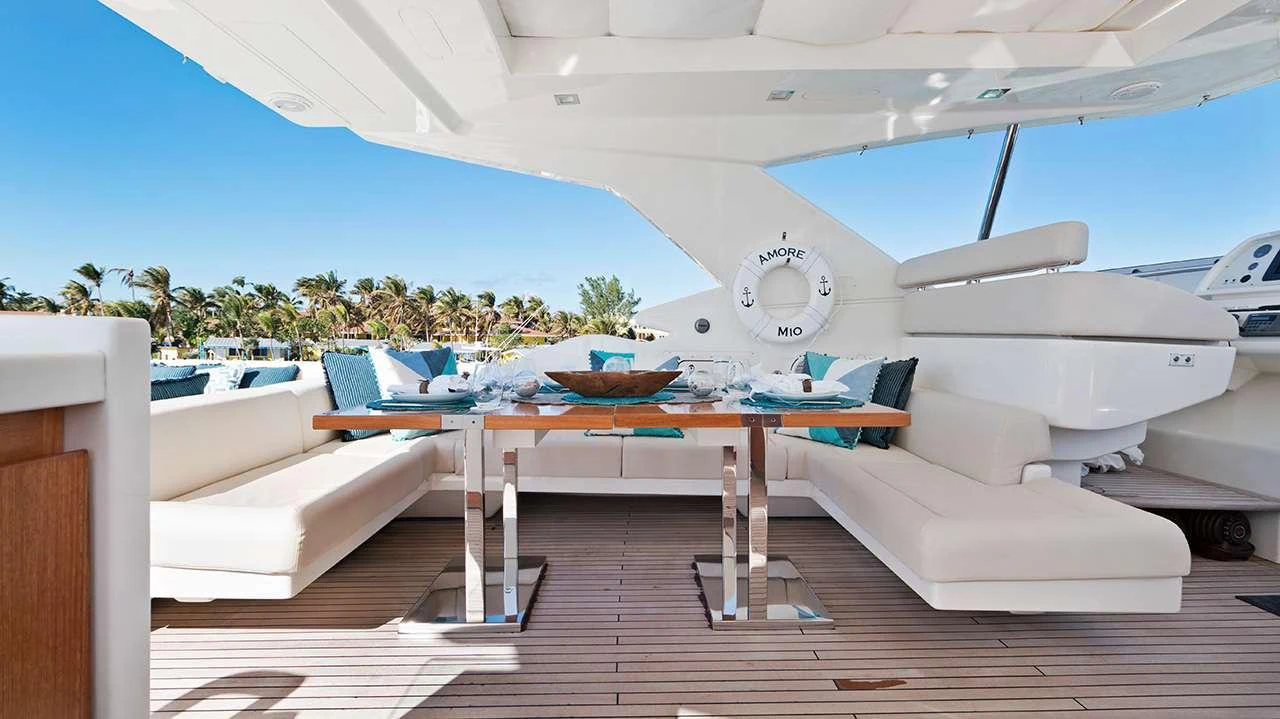 The aft deck features a stylish dining area with plush seating and a beautifully set table, perfect for alfresco dining. aboard LA MAR Yacht for Charter