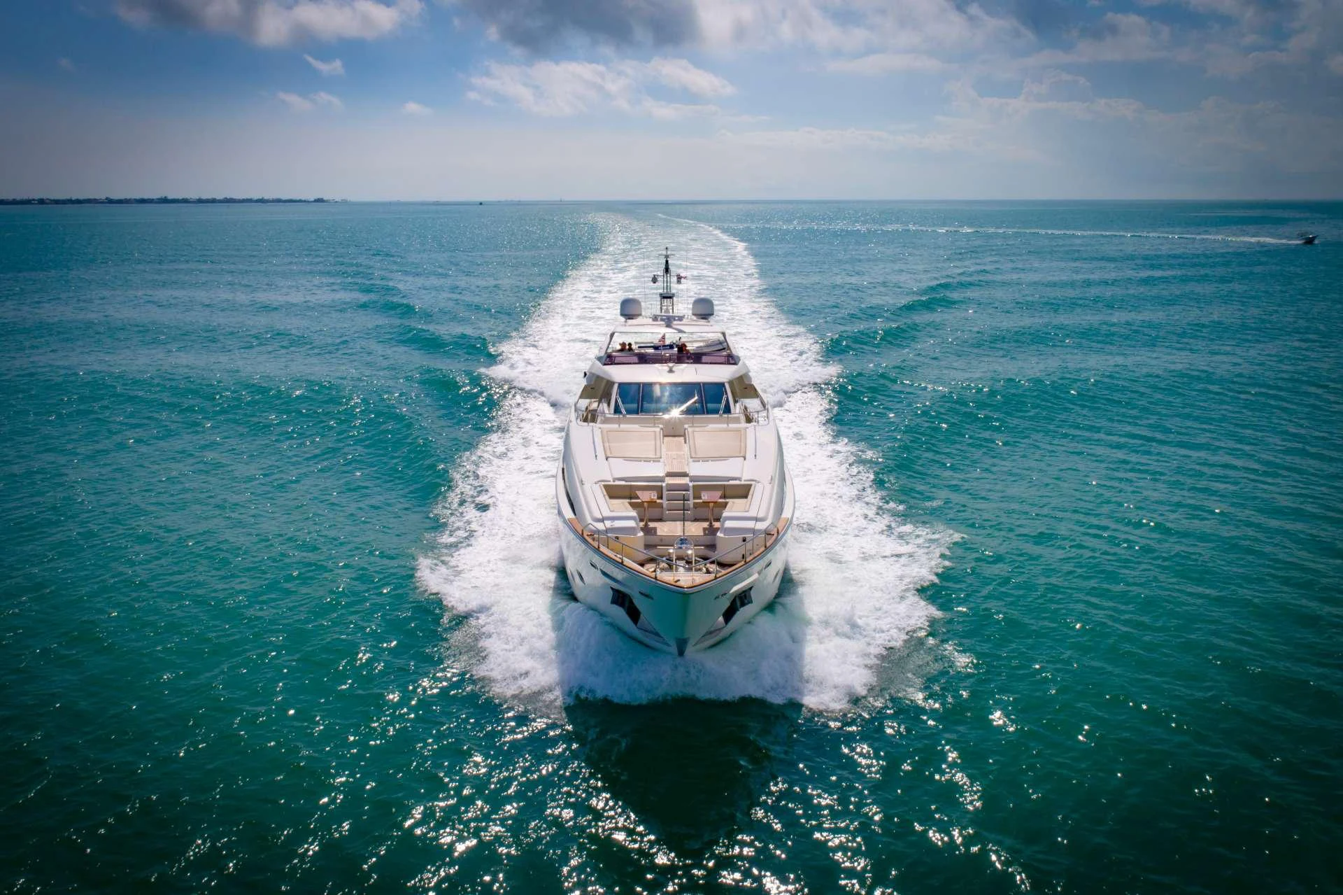 A luxurious yacht cruises through clear blue waters, leaving a trail of white foam behind. aboard LA MAR Yacht for Charter