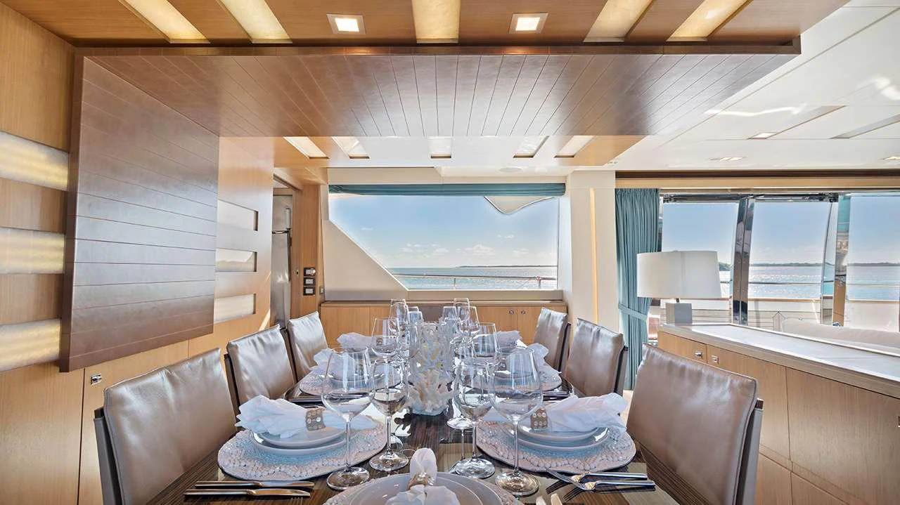 The yacht's dining area offers a luxurious setting with a stunning ocean view. aboard LA MAR Yacht for Charter