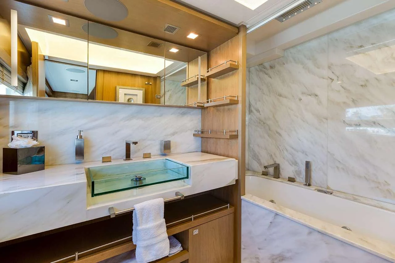 The yacht's bathroom features a luxurious marble design with modern fixtures and ample lighting. aboard LA MAR Yacht for Charter