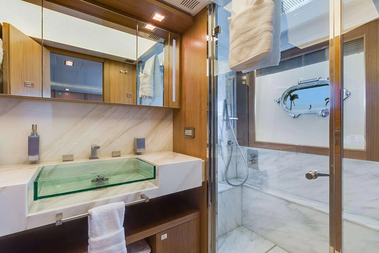 The yacht's bathroom features a modern design with a glass sink and a spacious shower area. aboard LA MAR Yacht for Charter
