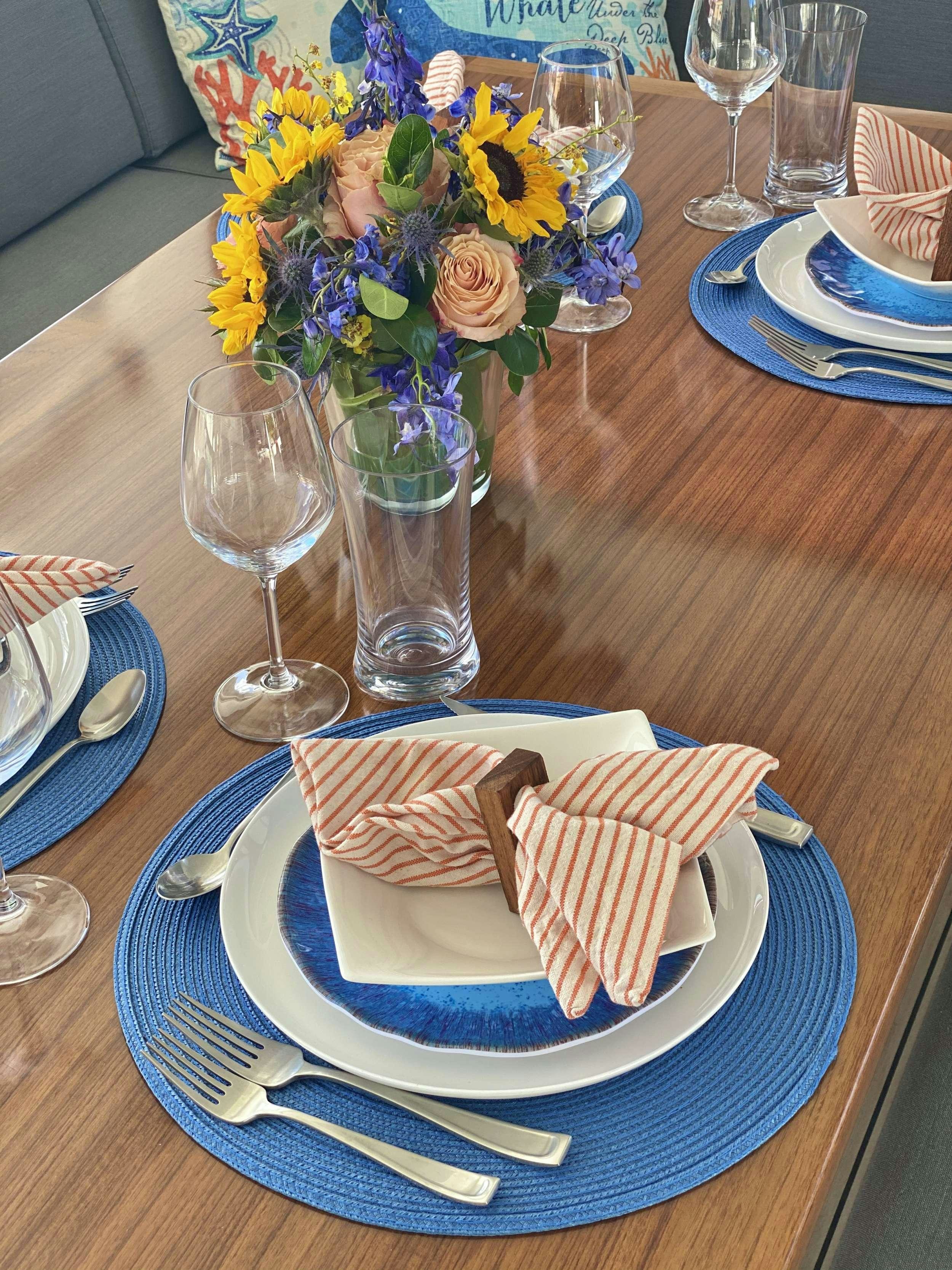 a table with a plate of sandwiches and flowers aboard O.V. Yacht for Charter