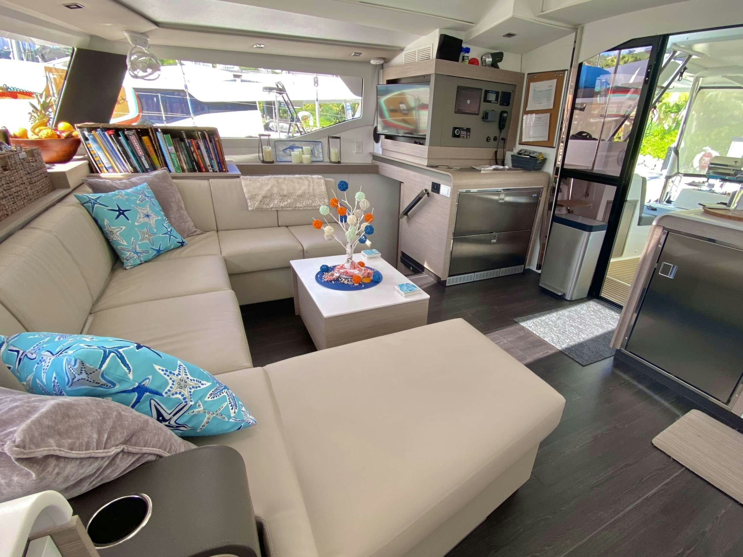 a living room with a couch and a table aboard O.V. Yacht for Charter