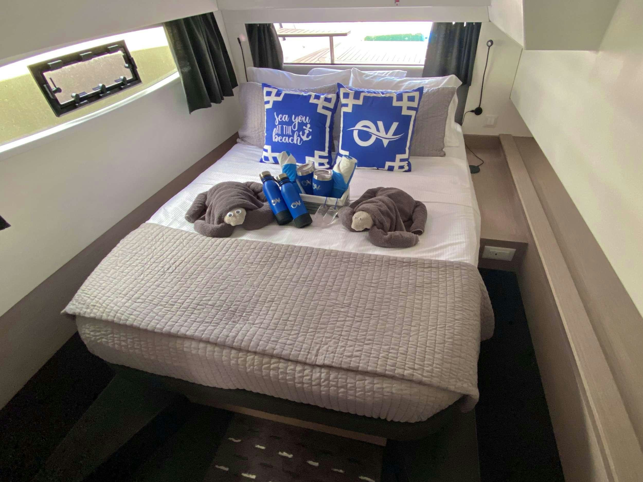 a bed with blue and white pillows aboard O.V. Yacht for Charter