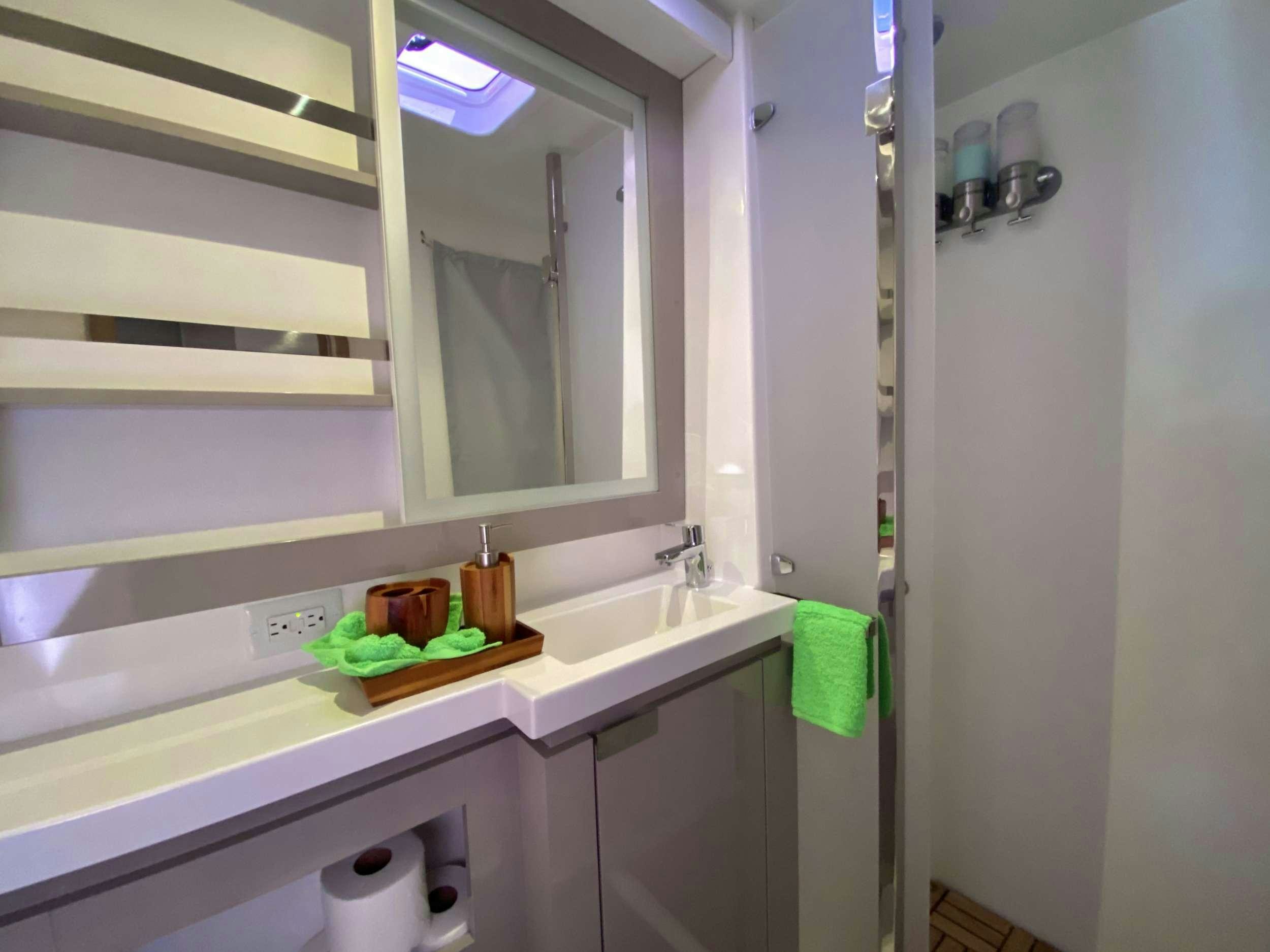 a bathroom with a sink and mirror aboard O.V. Yacht for Charter