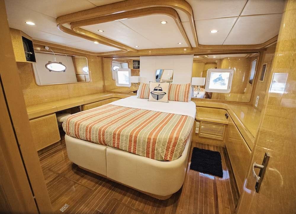 a room with a bed and a desk aboard COOL BREEZE 65 Yacht for Charter