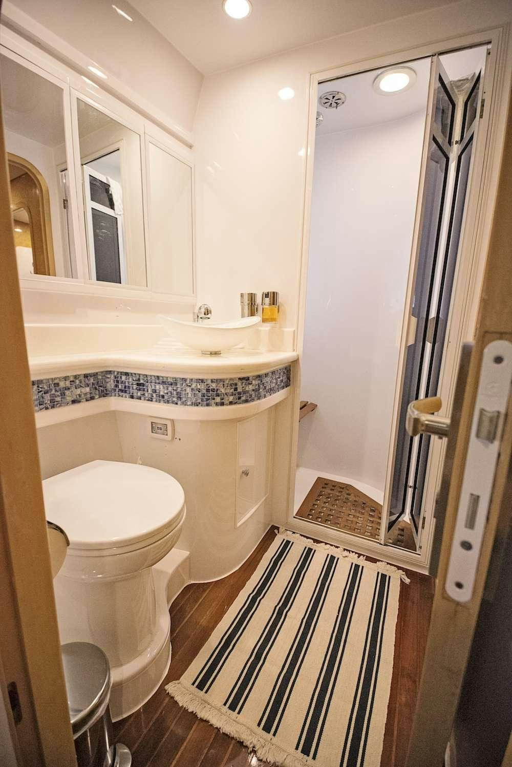 a bathroom with a tub sink and toilet aboard COOL BREEZE 65 Yacht for Charter