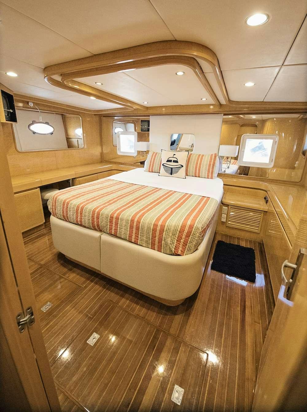 a room with a bed and a desk aboard COOL BREEZE 65 Yacht for Charter