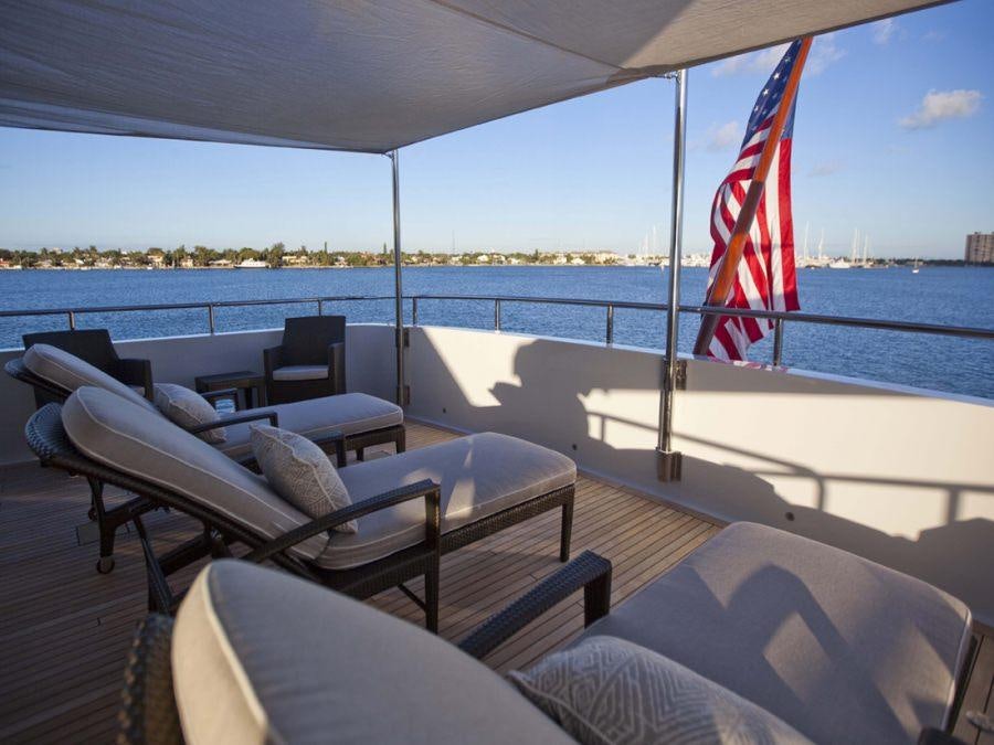 a boat with chairs and a flag on the deck aboard LEVERAGE Yacht for Charter
