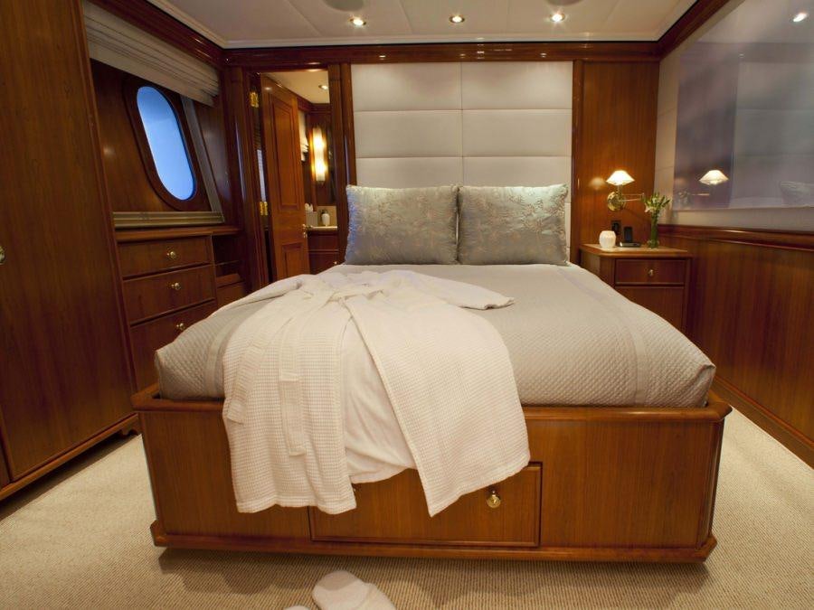 a bed with a white sheet aboard LEVERAGE Yacht for Charter
