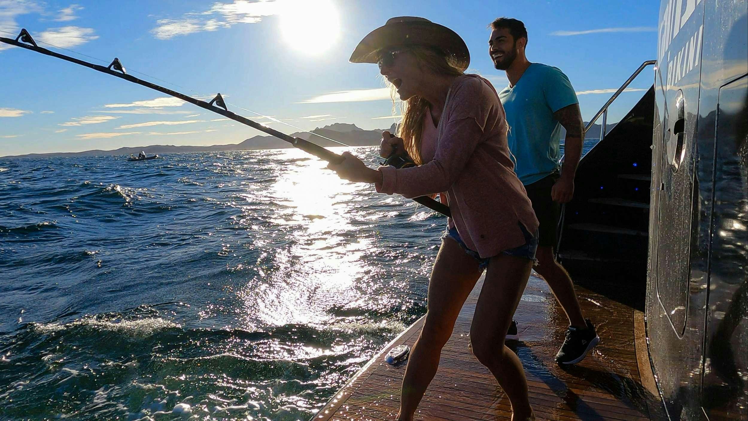 a man and woman walking on a dock on a boat aboard SAMSARA Yacht for Charter