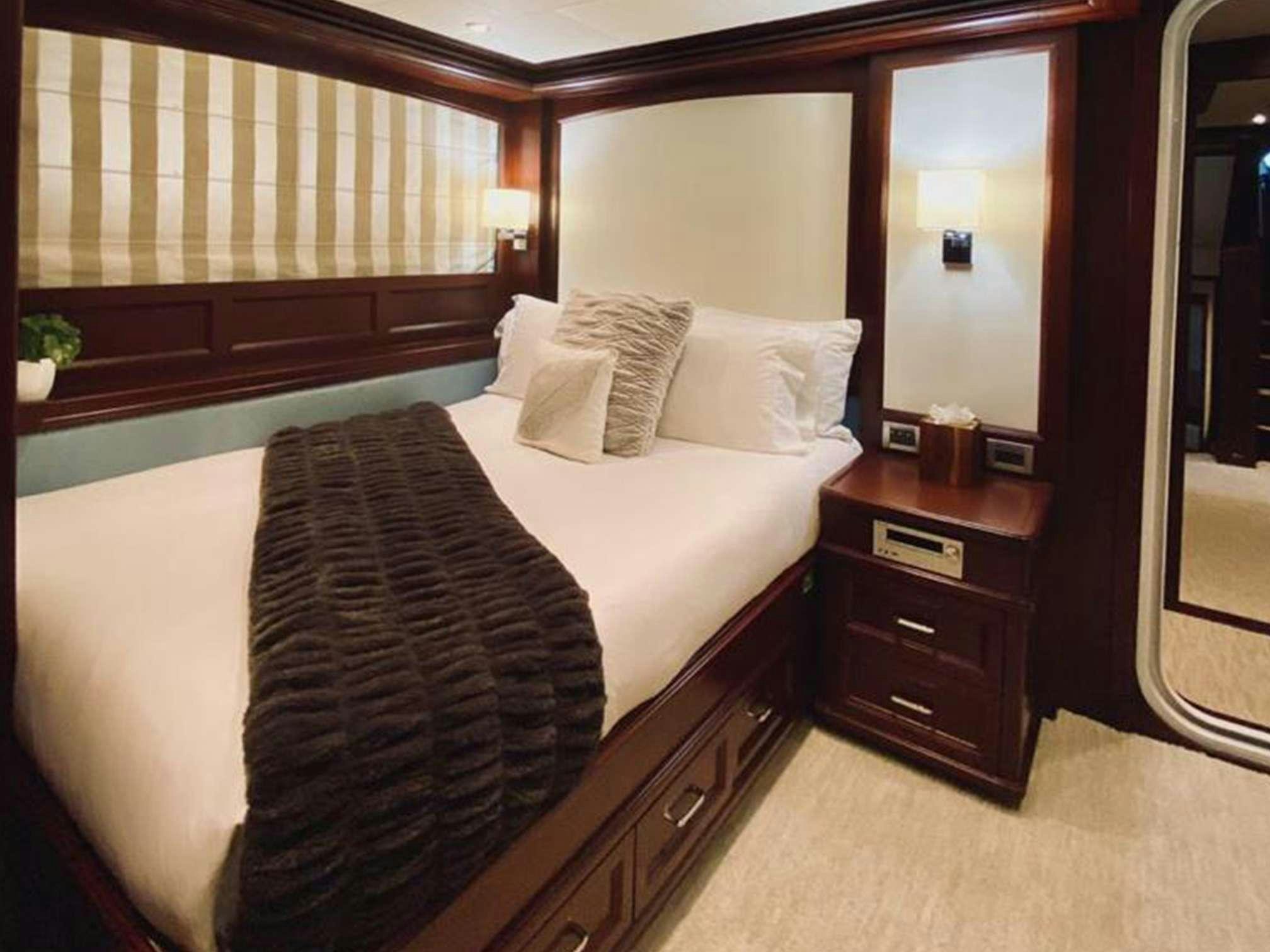 a bed with a black and white blanket aboard SAMSARA Yacht for Charter