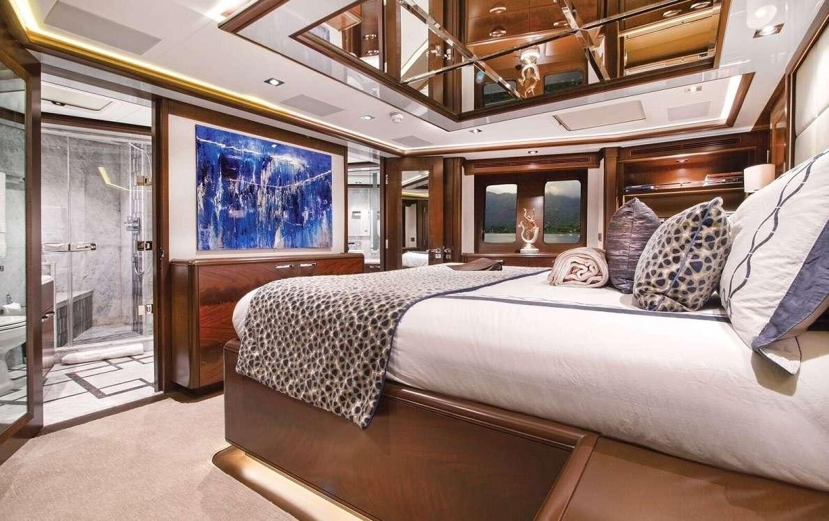 a bedroom with a bed and a mirror aboard VIVIERAE II Yacht for Charter