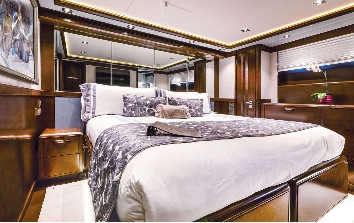 a bedroom with a bed and a mirror aboard VIVIERAE II Yacht for Charter