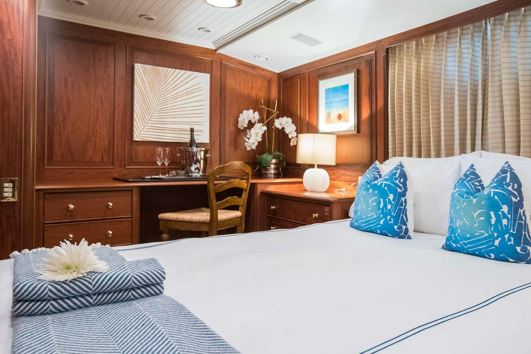a bed with white sheets and pillows aboard LADY J Yacht for Charter