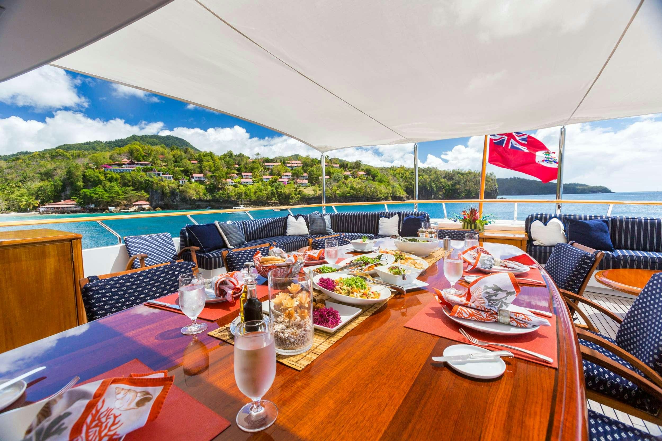 a table set with food and wine glasses aboard LADY J Yacht for Charter