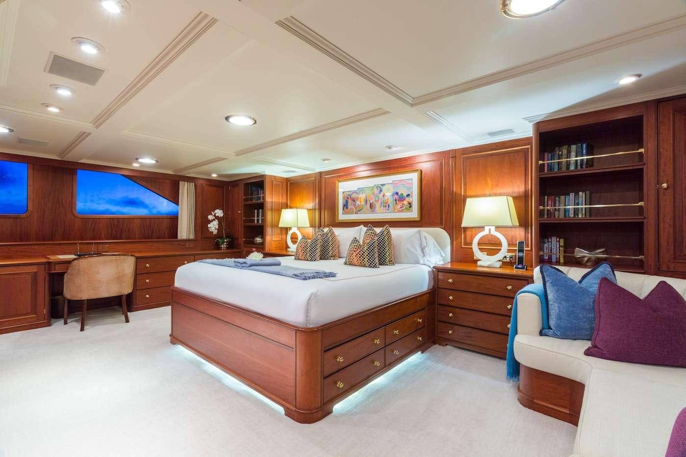 a bedroom with a bed and a desk aboard LADY J Yacht for Charter