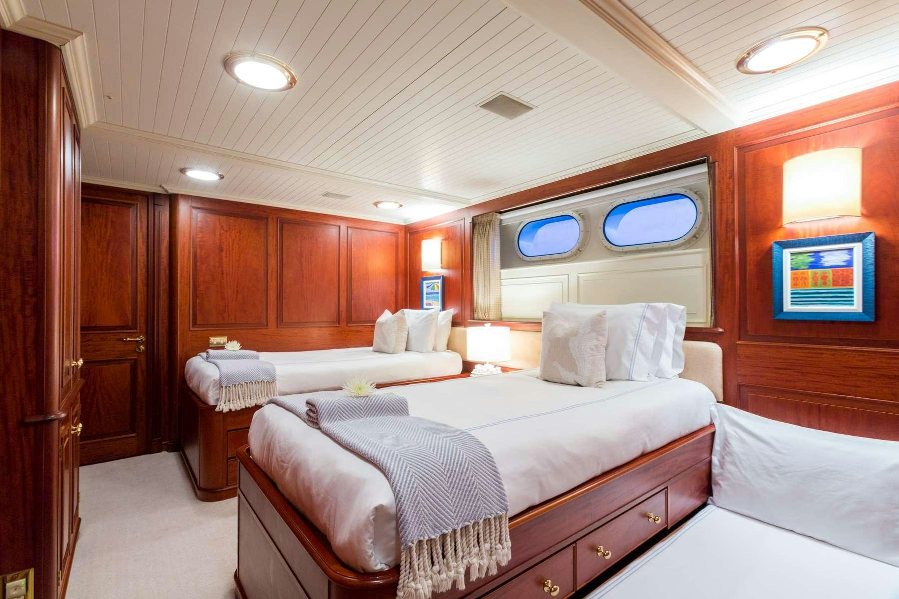 a room with a bed and a desk aboard LADY J Yacht for Charter