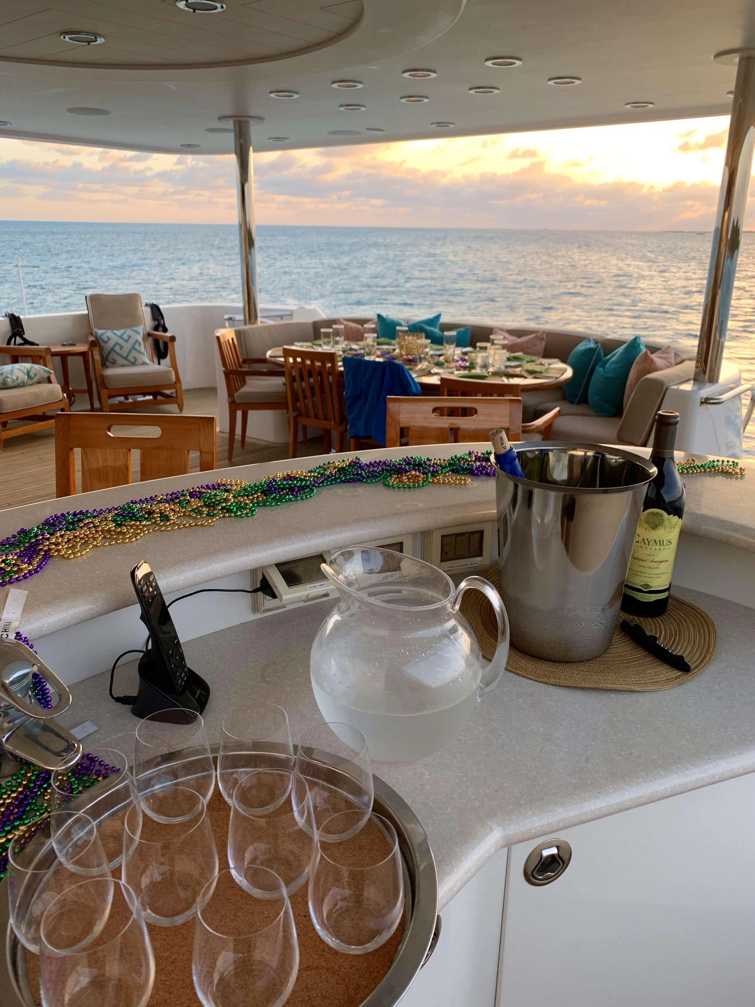 a table with a glass and a bottle on it aboard RELENTLESS Yacht for Charter