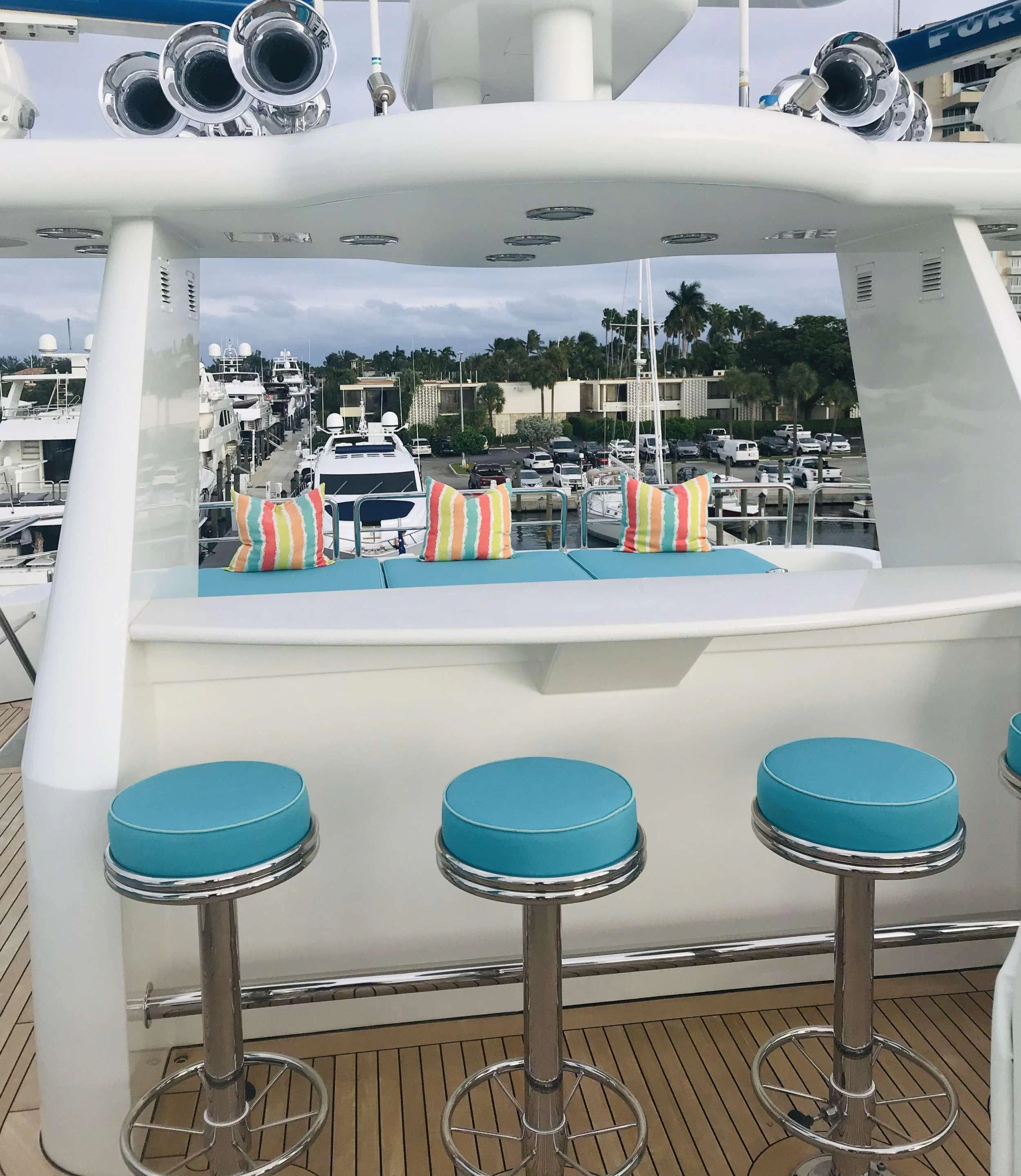 a boat with a table and stools aboard RELENTLESS Yacht for Charter