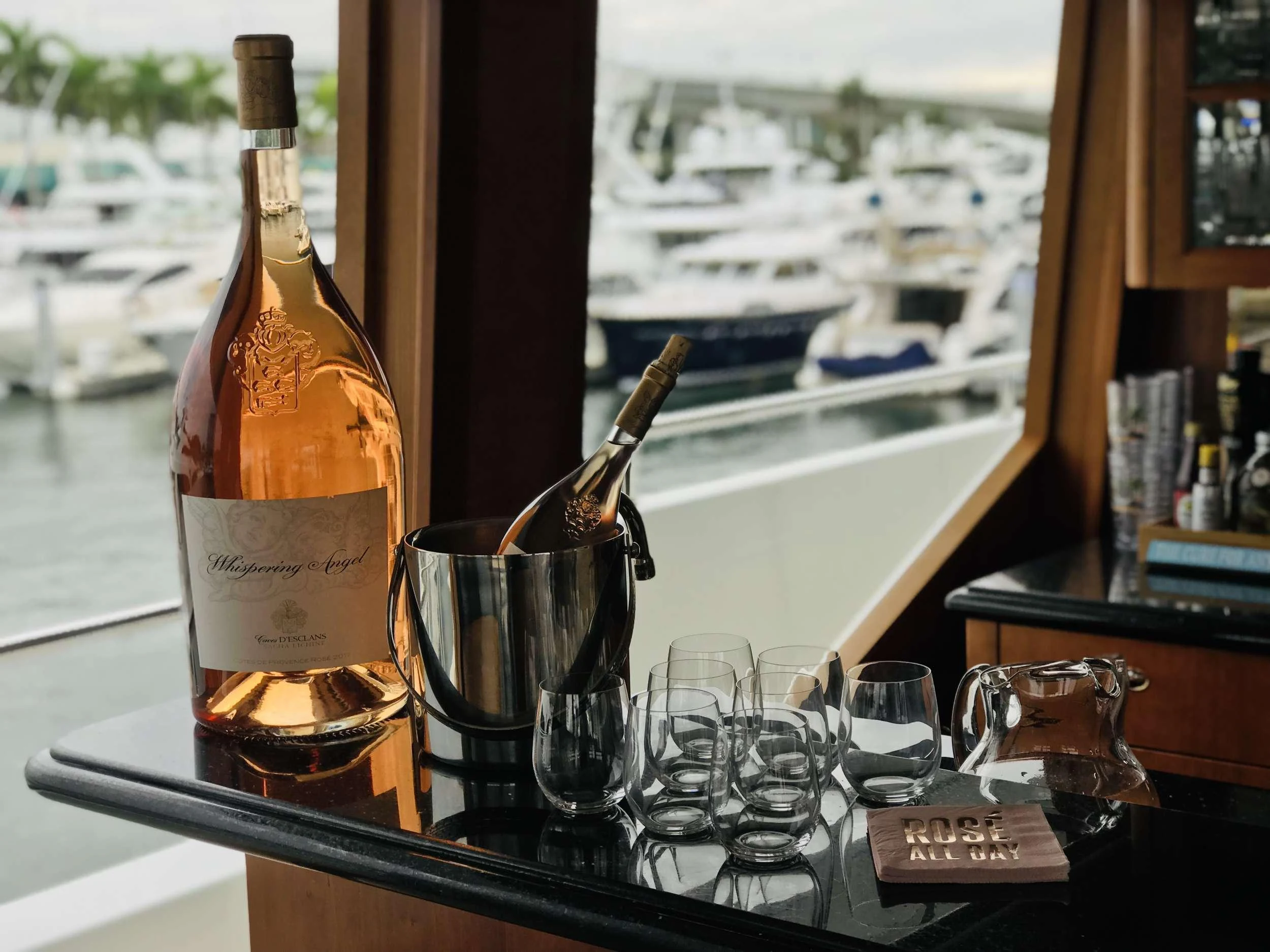 a bottle of wine and glasses on a table aboard RELENTLESS Yacht for Charter