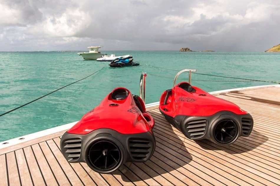 a red and white boat on a dock with boats in the water aboard PURA VIDA Yacht for Charter