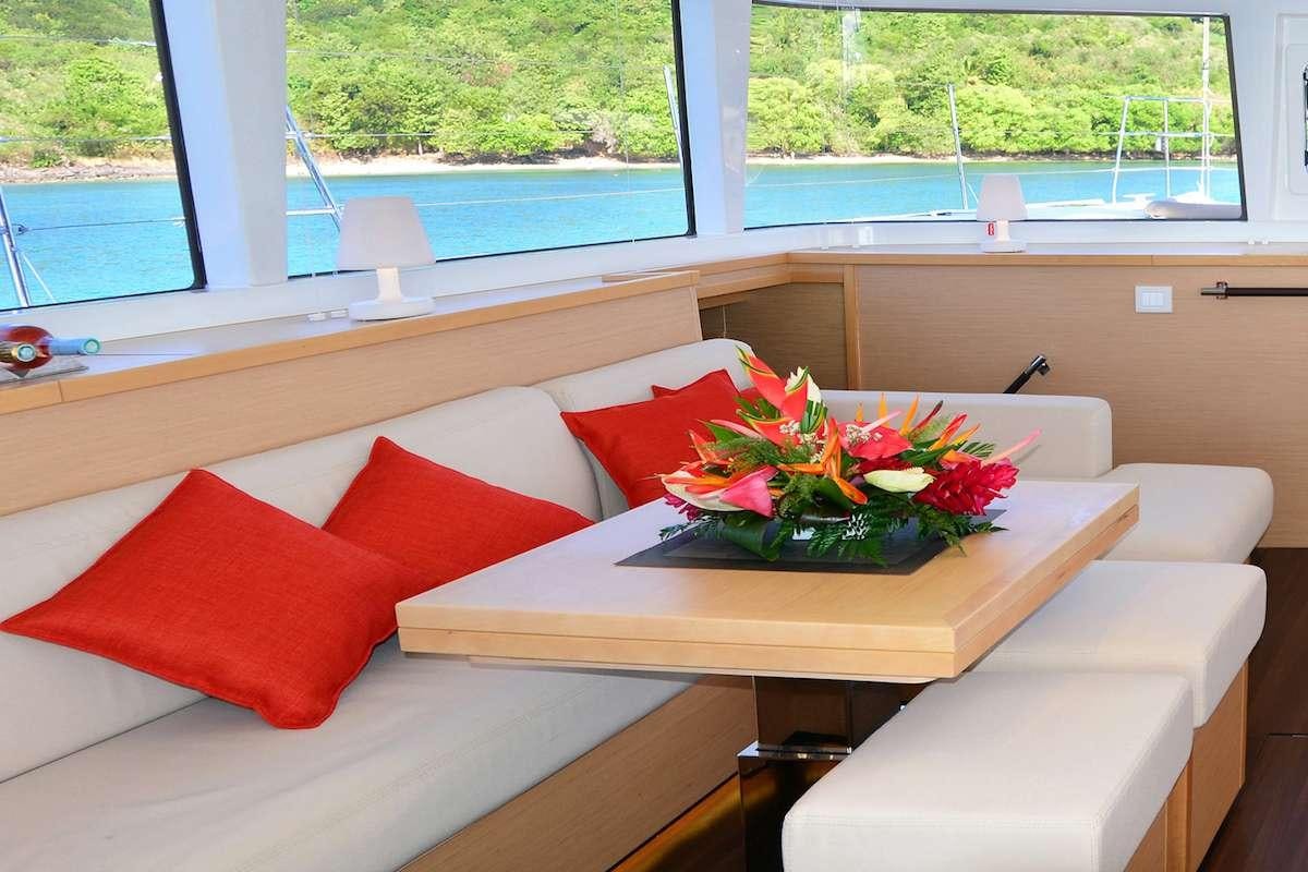 a table with red pillows on it aboard BACCHUS Yacht for Charter