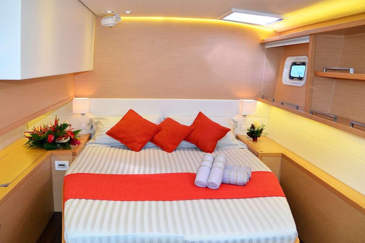 a bed with red and white pillows aboard BACCHUS Yacht for Charter