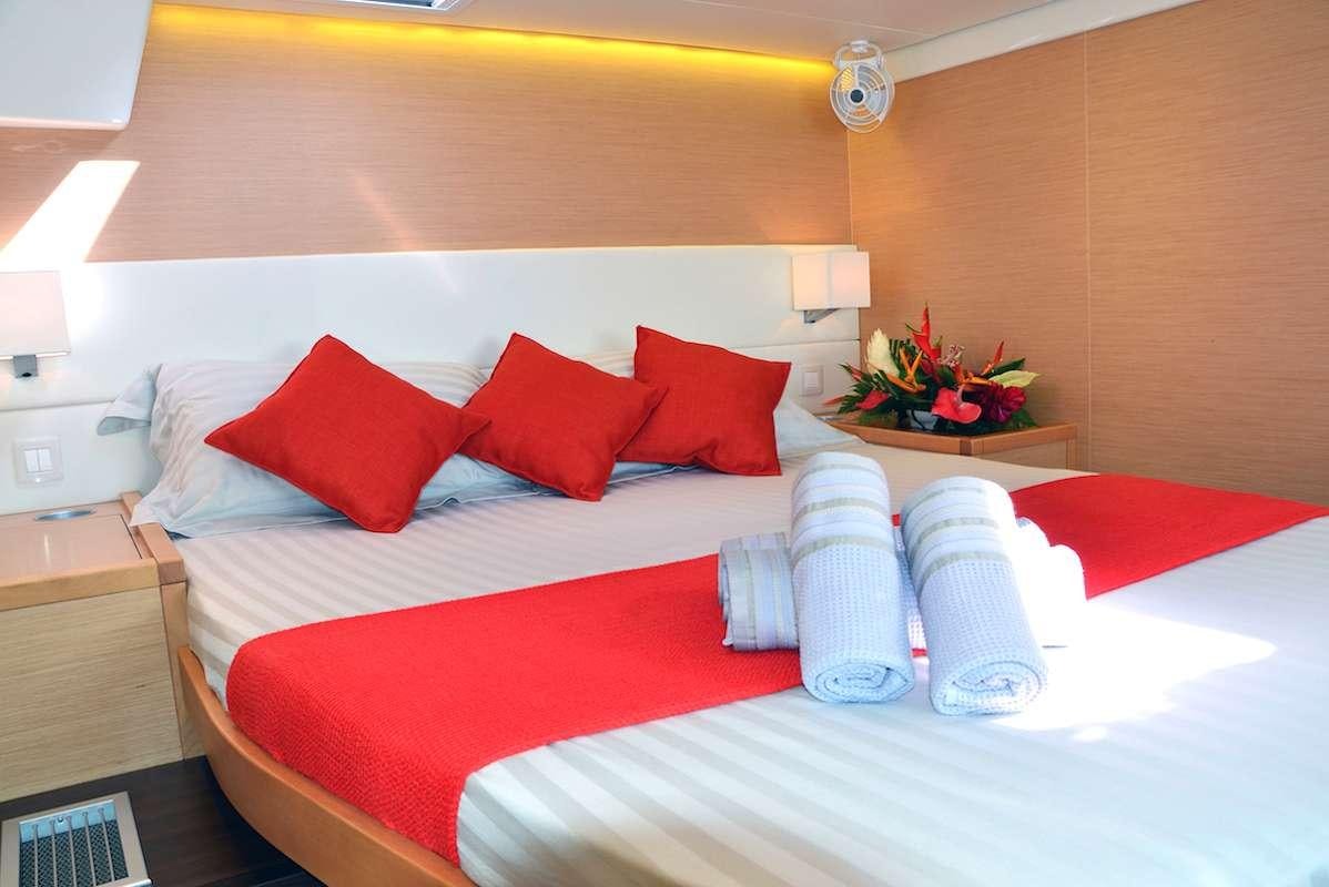 a hotel room with a bed and pillows aboard BACCHUS Yacht for Charter