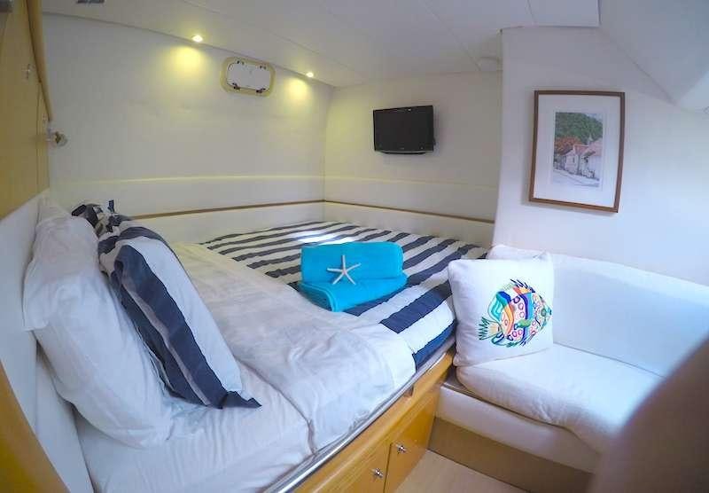 a bedroom with a bed and a television aboard KELEA Yacht for Charter