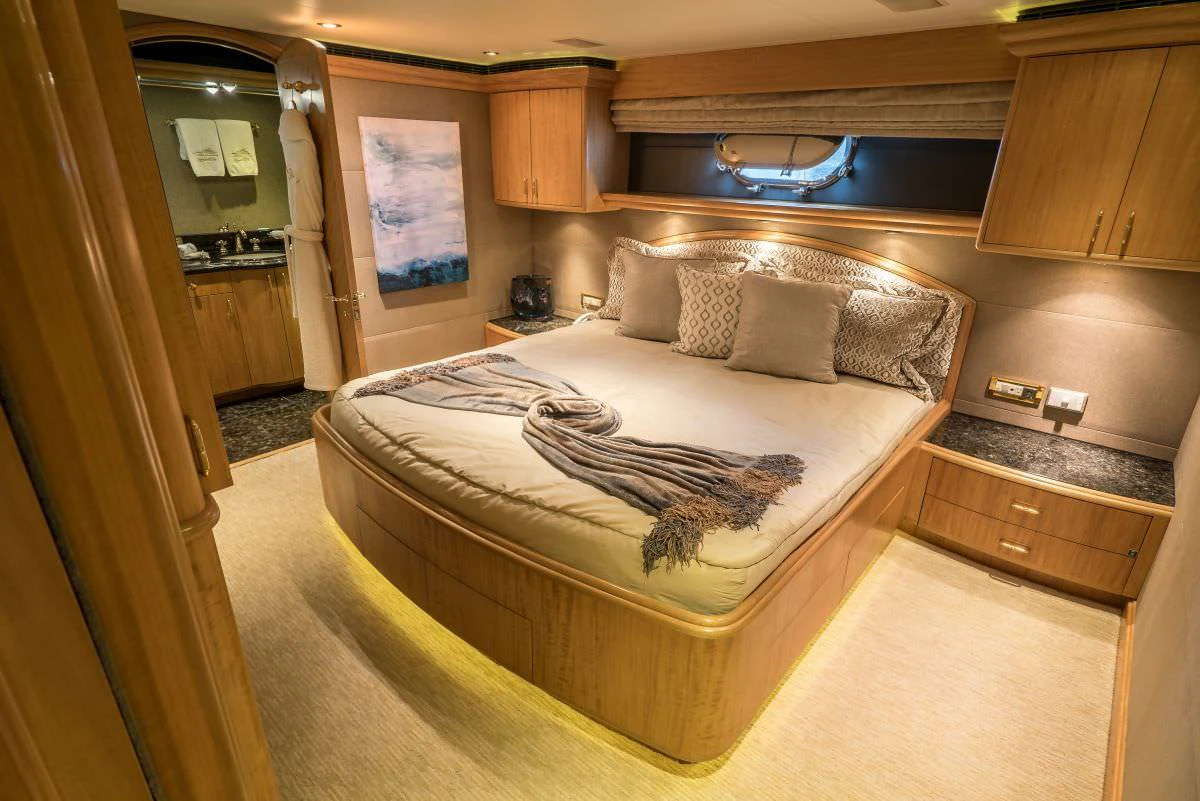 The master stateroom features a luxurious bed with elegant bedding and warm wood finishes. aboard CHARLOTTE ANN Yacht for Charter