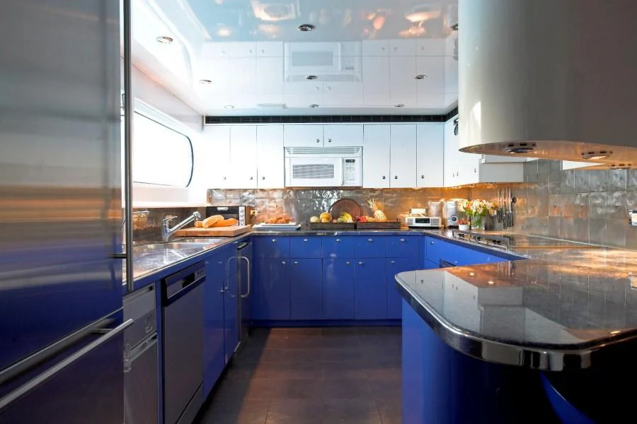 The yacht's galley features modern appliances and vibrant blue cabinetry, creating a stylish and functional space. aboard CHARLOTTE ANN Yacht for Charter