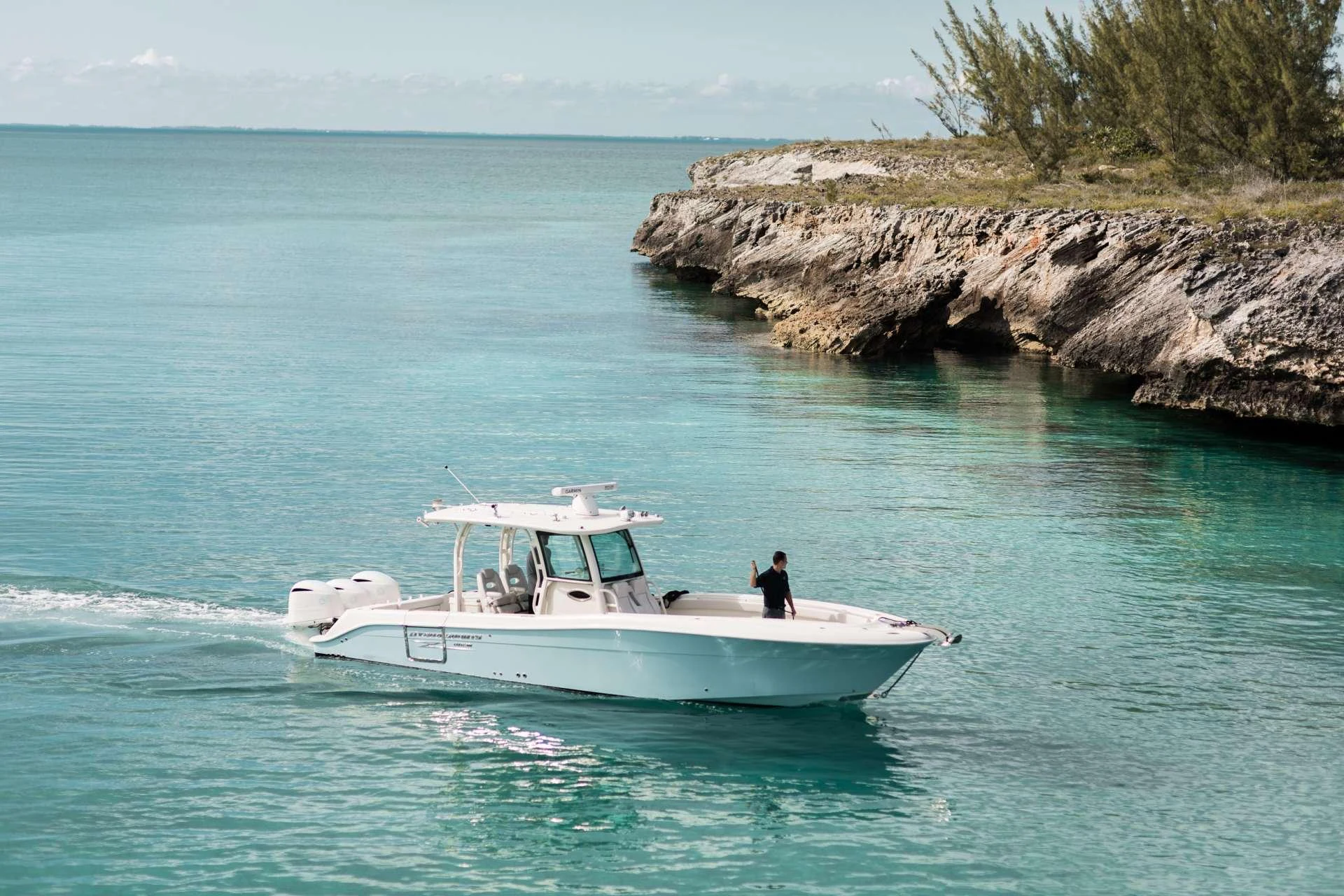 A sleek yacht cruises along a serene coastline with clear turquoise waters. aboard CHARLOTTE ANN Yacht for Charter