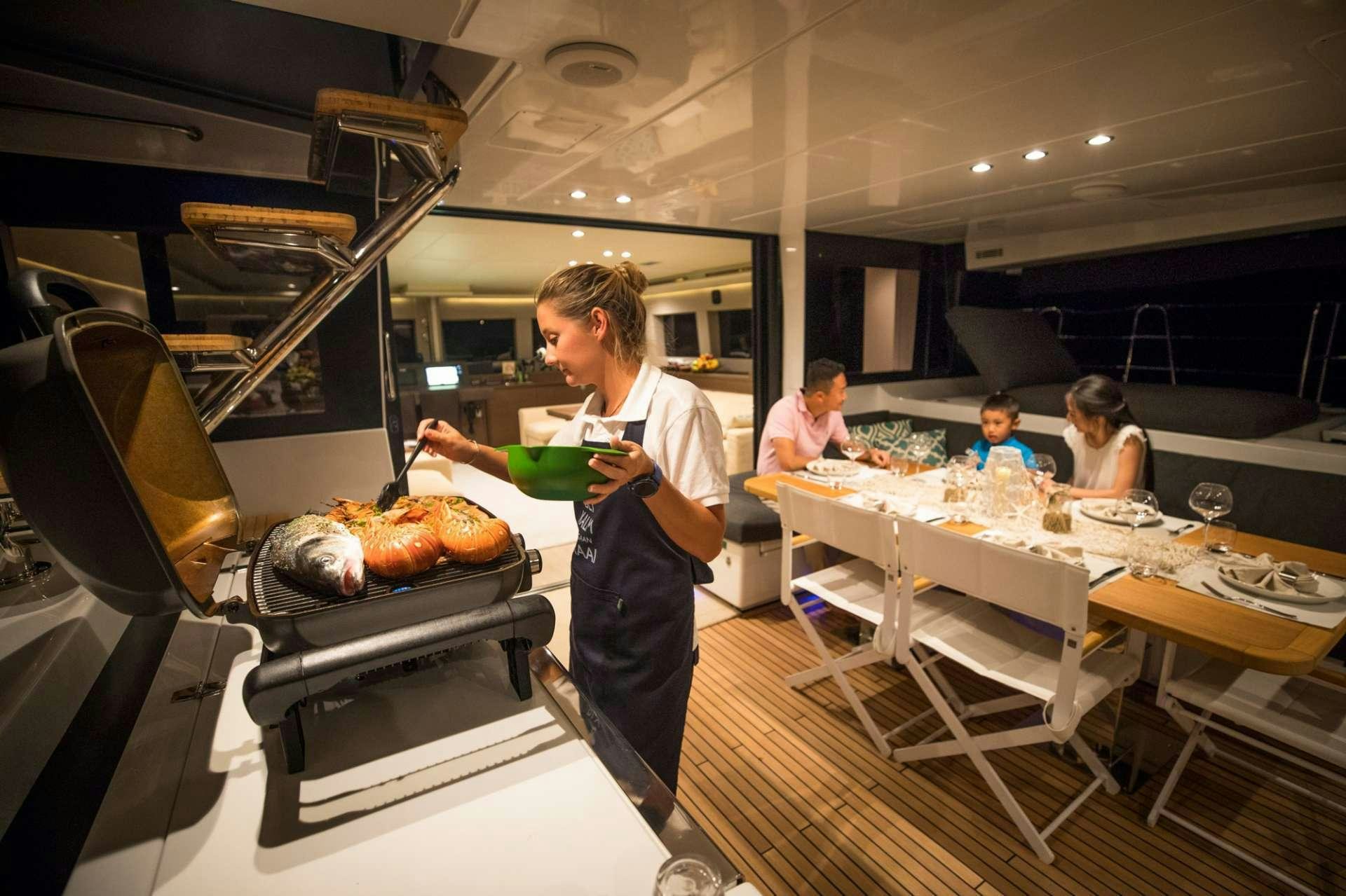 a man cooking food in a kitchen aboard LADY FIONA Yacht for Charter