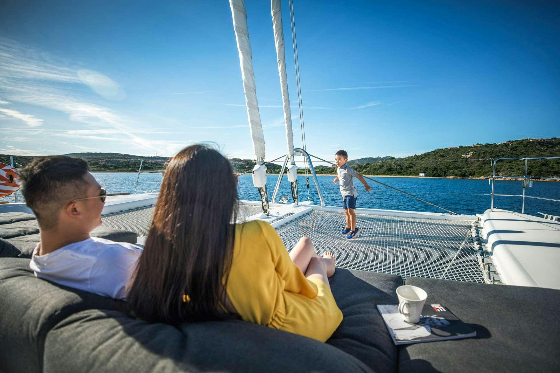 a man and woman sitting on a boat looking at a man standing on the deck of a boat aboard LADY FIONA Yacht for Charter