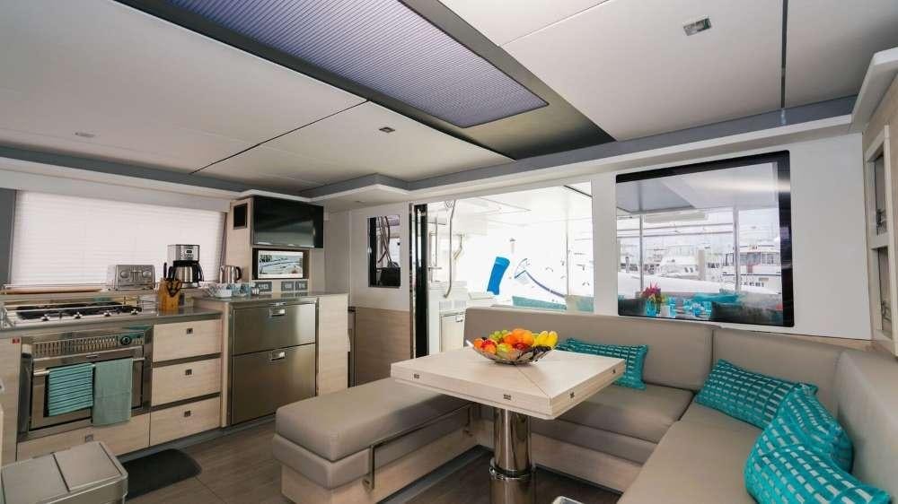 a kitchen with a table and couches aboard MOON BLOSSOM Yacht for Charter