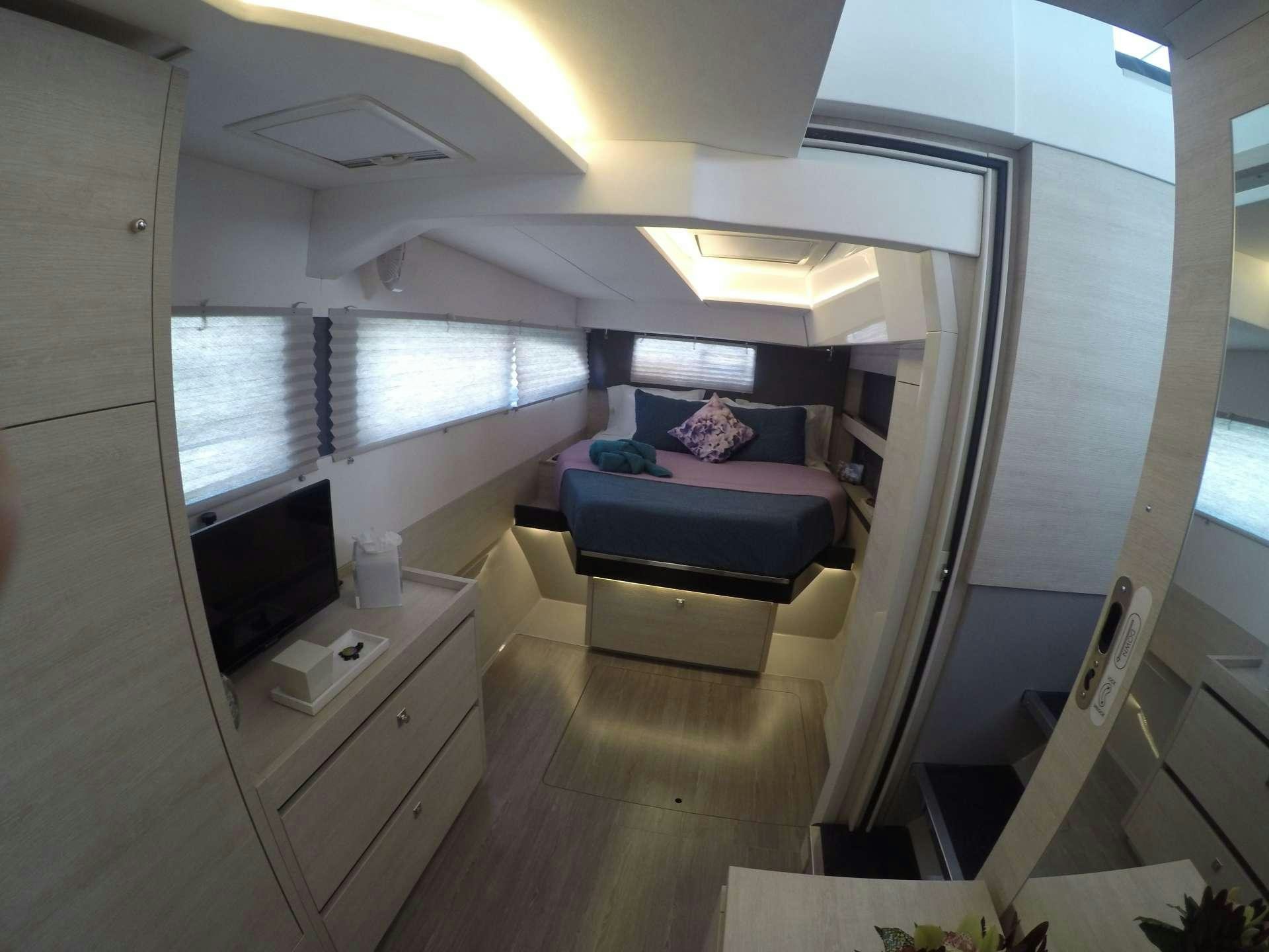 a room with a bed and a tv aboard MOON BLOSSOM Yacht for Charter