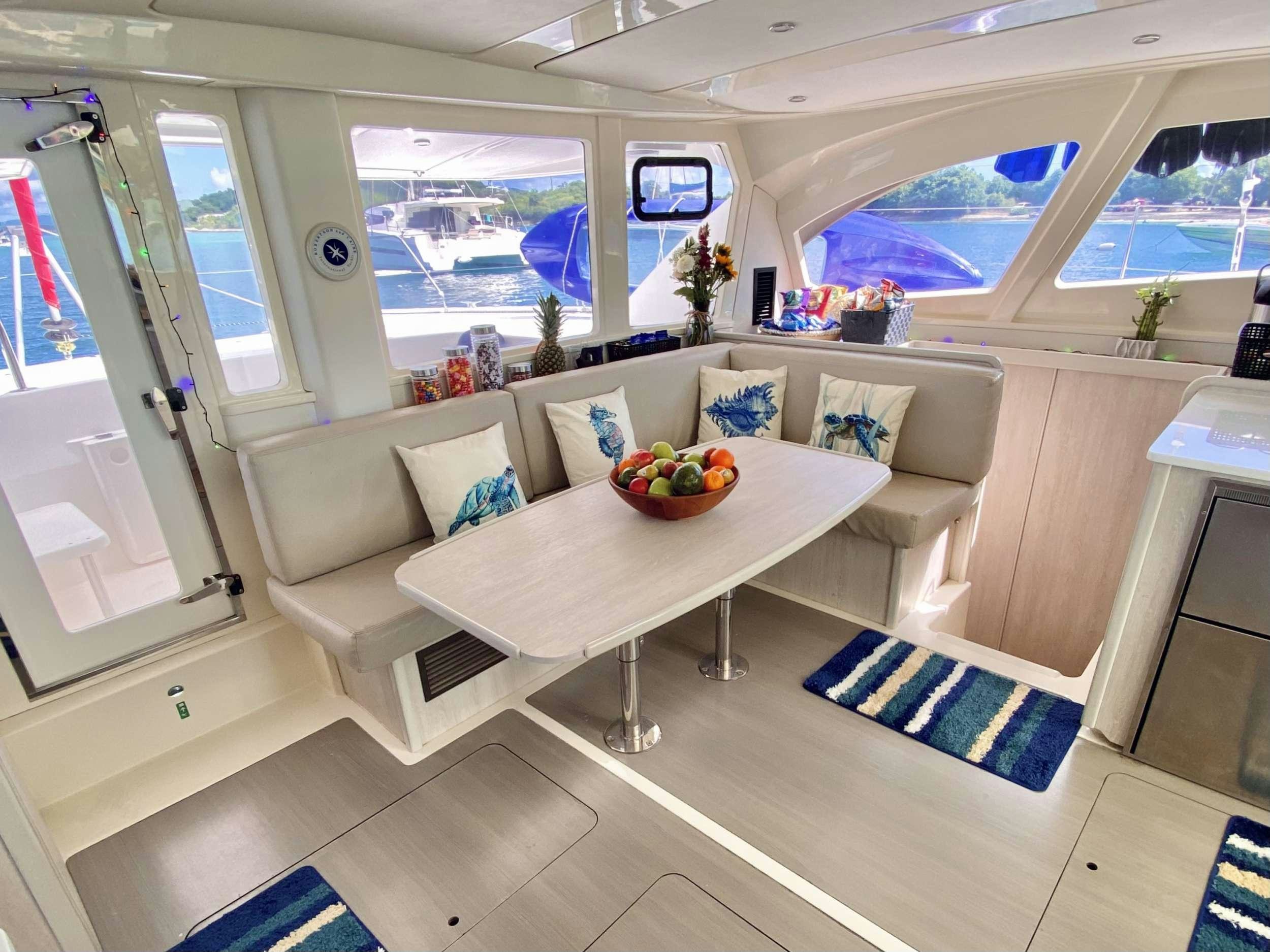 a living room with a couch and a table aboard LET'S PLAY TWO Yacht for Charter