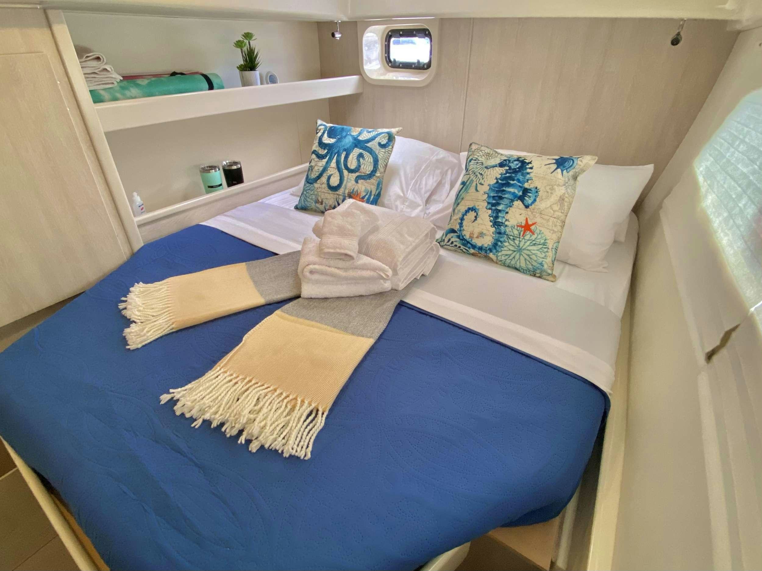 a bed with pillows and blankets aboard LET'S PLAY TWO Yacht for Charter