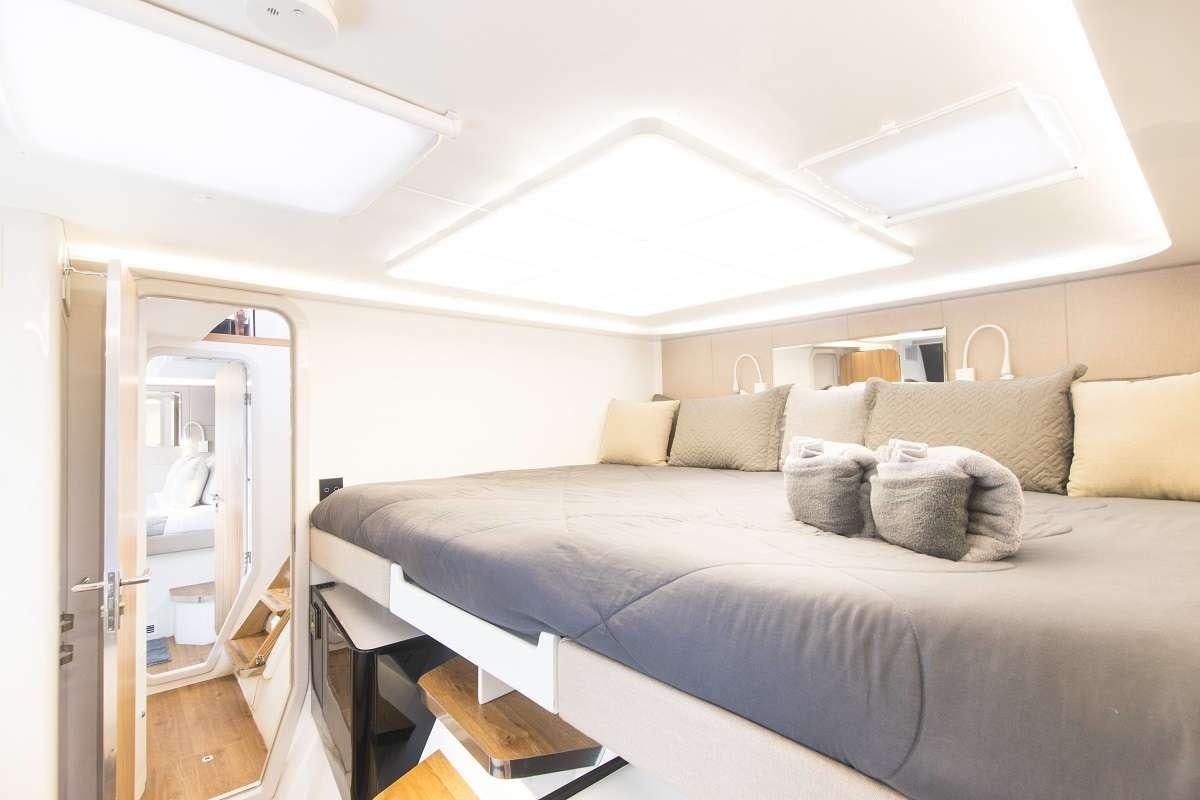 a bed with a white bed spread aboard SANTA ANA Yacht for Charter