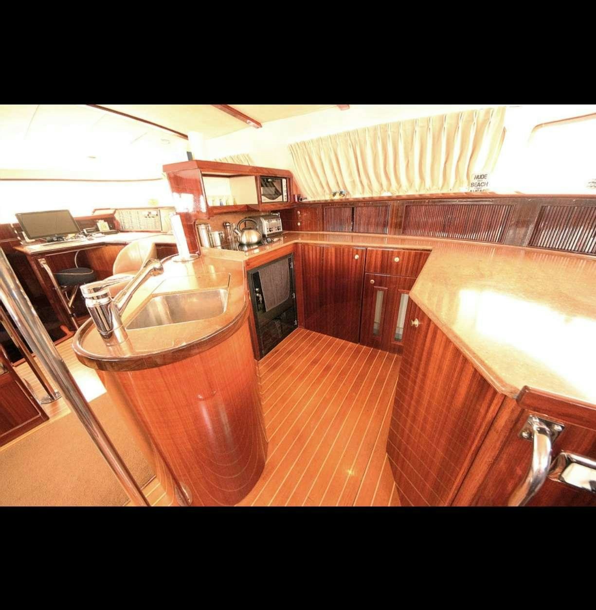 a kitchen with wooden cabinets aboard SOUTHERN PASSAGE Yacht for Charter