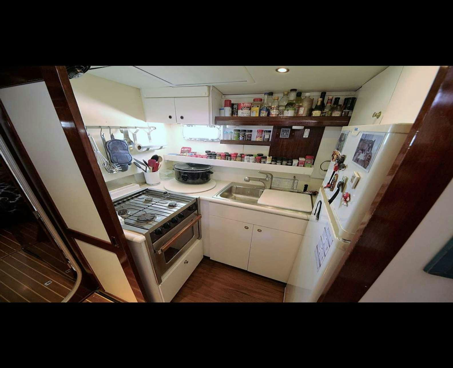 a kitchen with a stove and shelves aboard SOUTHERN PASSAGE Yacht for Charter