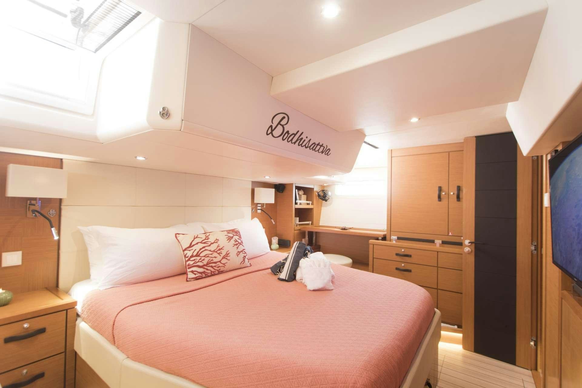 a bed with a pink comforter aboard BODHISATTVA (Caribbean) Yacht for Charter
