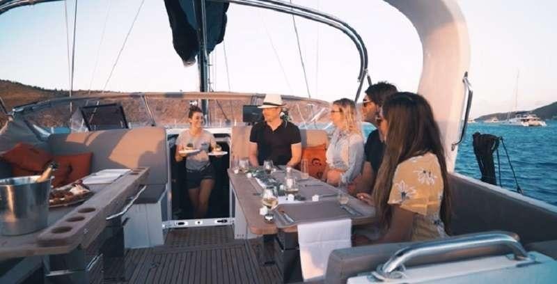 a group of people sitting at a table with food on it aboard BODHISATTVA (Caribbean) Yacht for Charter