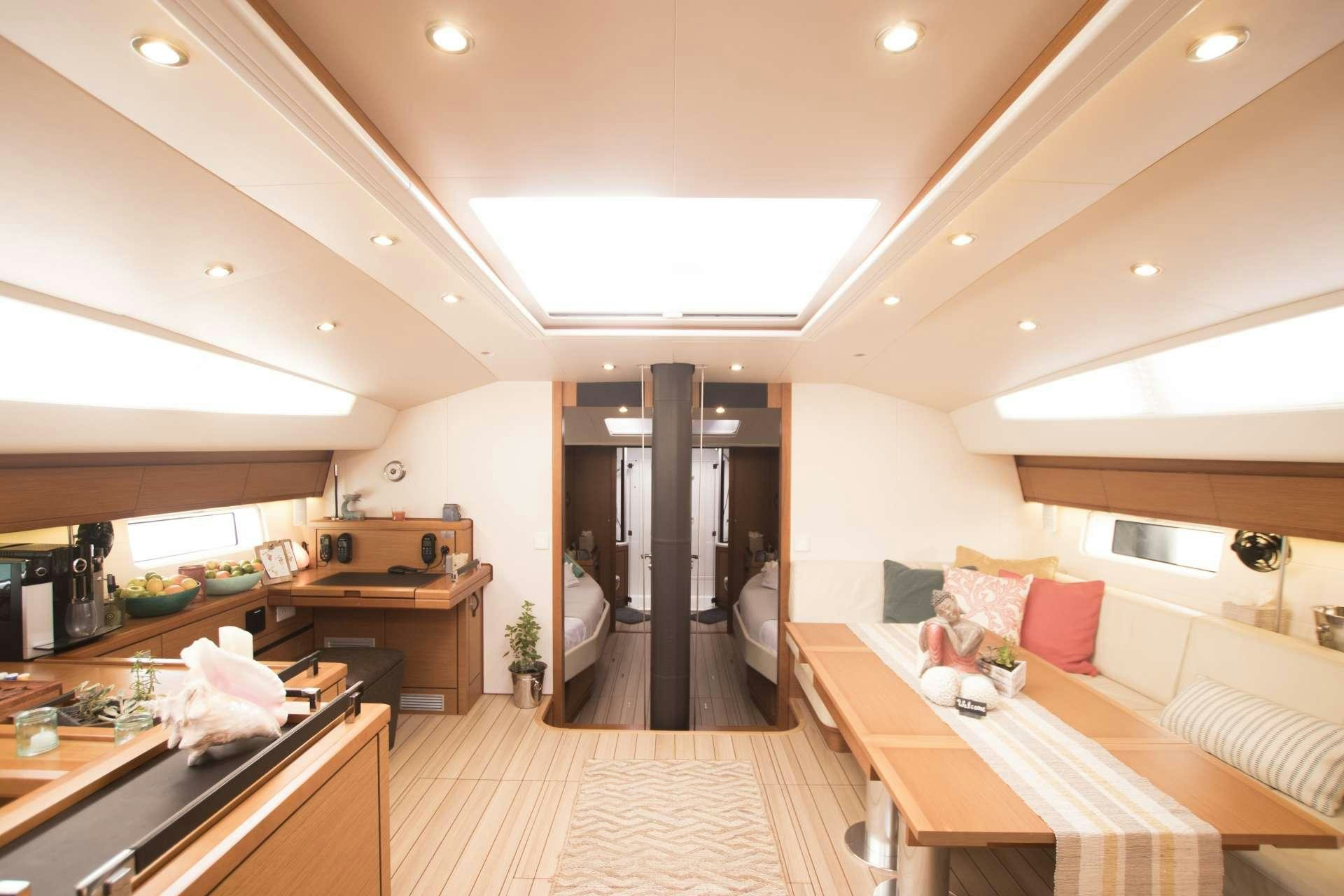 a large room with a bed and a table aboard BODHISATTVA (Caribbean) Yacht for Charter