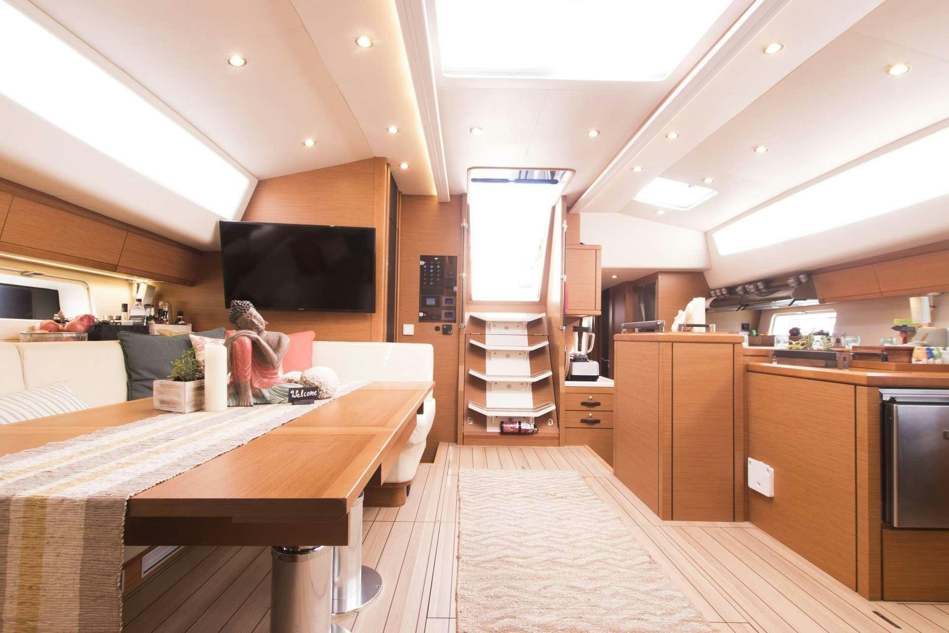 a room with a table and a tv aboard BODHISATTVA (Caribbean) Yacht for Charter