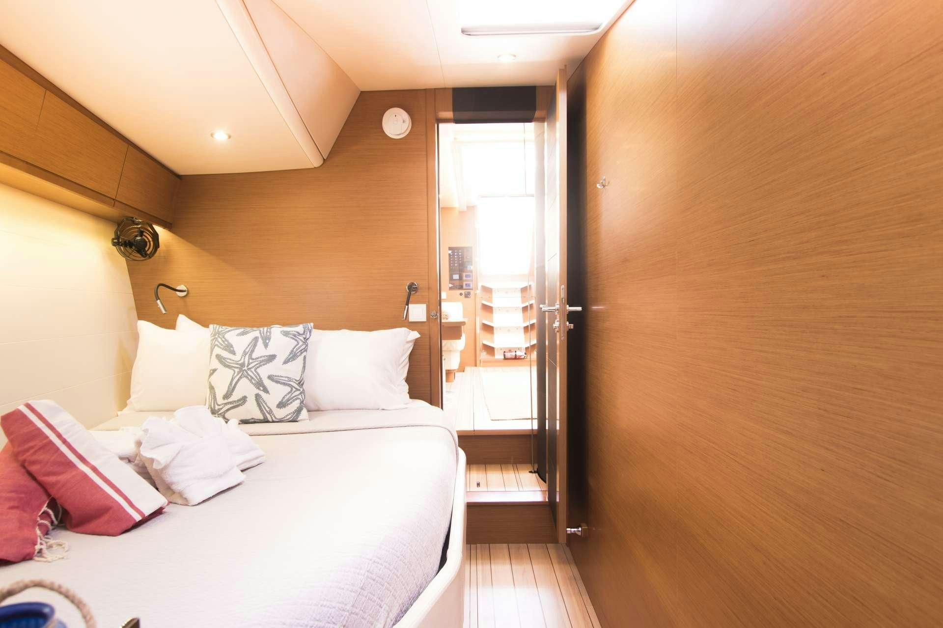 a room with a bed and a door aboard BODHISATTVA (Caribbean) Yacht for Charter