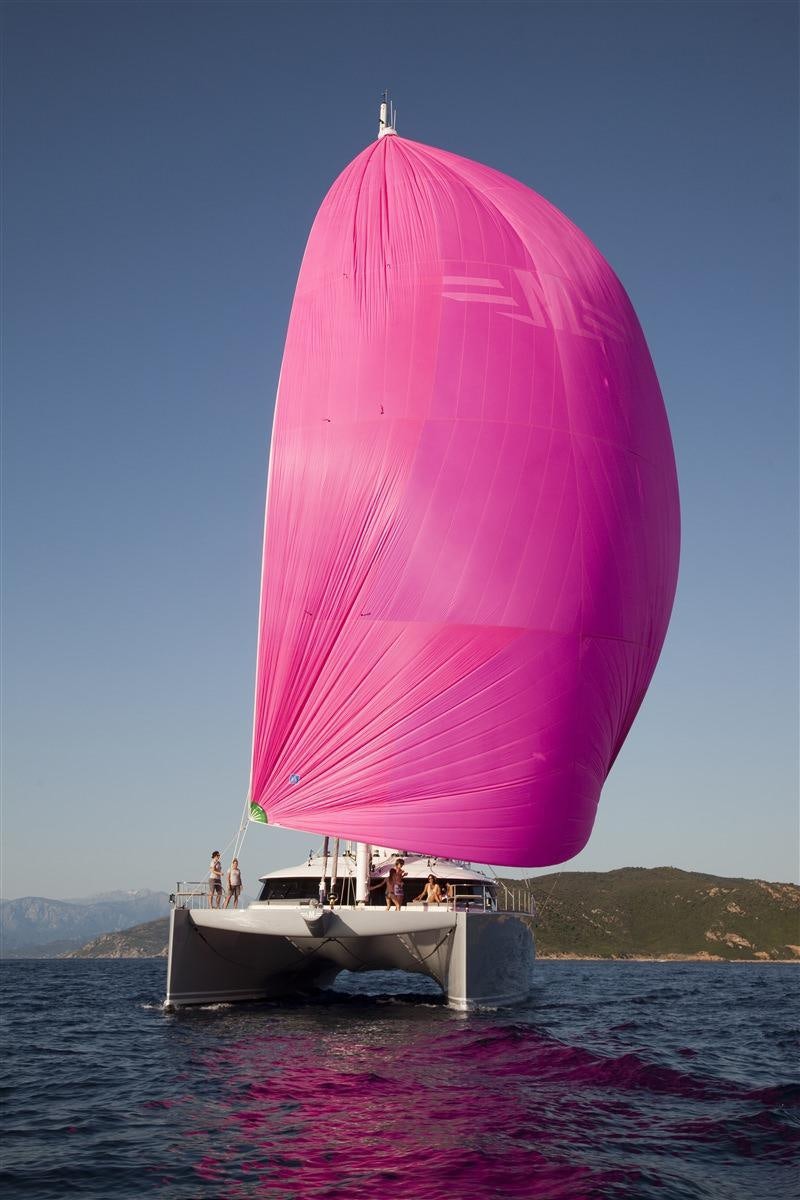 a sailboat with a pink sail aboard MAVERICK Yacht for Charter